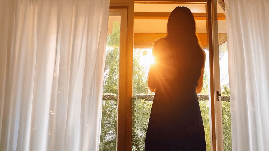 Woman at open window, symbolizing having joy even in sorrow.